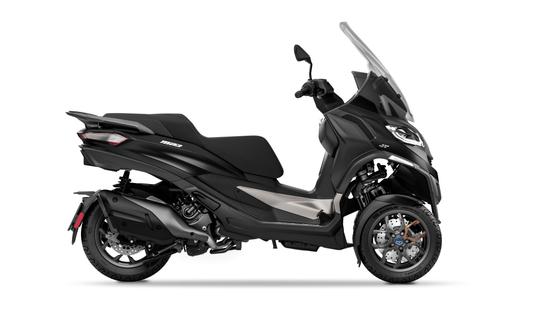 A side view of a modern black maxi-scooter against a white background.