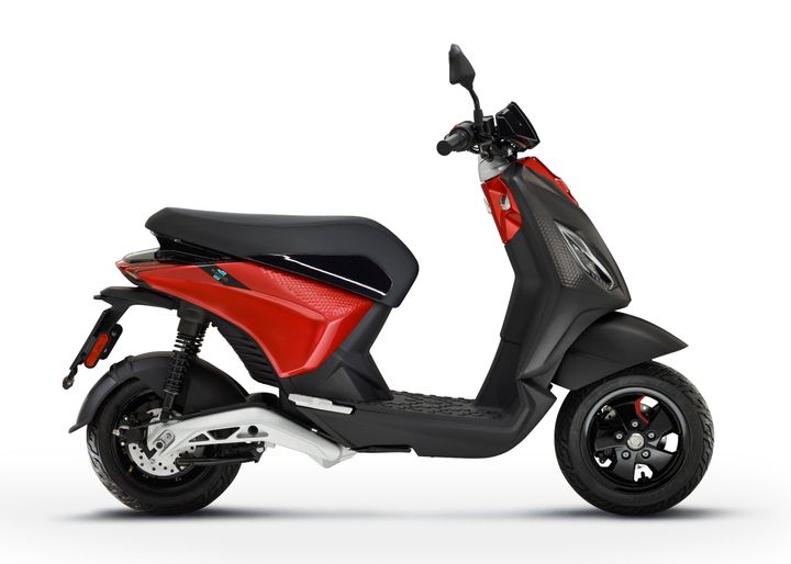 A modern red and black electric scooter against a white background.