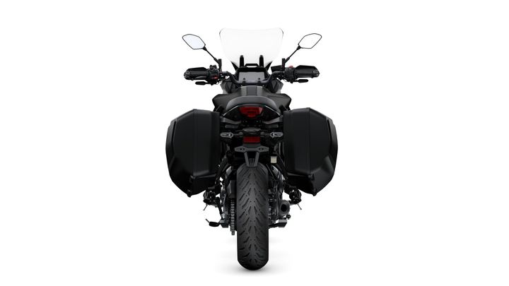 A black motorcycle seen from the rear, featuring side panniers, a sleek tail light, and a prominent windshield. The background is a plain white.