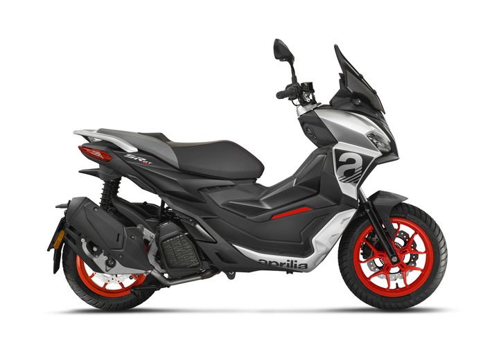 A modern Aprilia scooter with red and black wheels, positioned in a profile view on a white background.