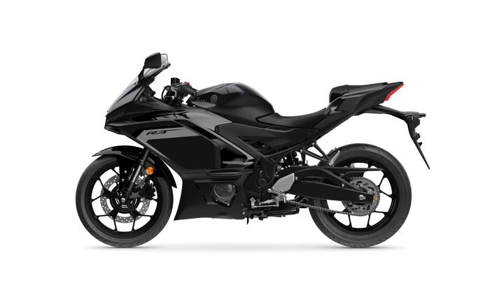 A sleek black sport motorcycle, the Yamaha YZF-R3, shown from the side with a streamlined body, sport fairings, and distinctive design elements.