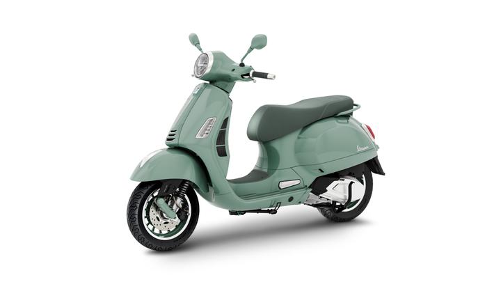 A mint green scooter with a classic design, featuring a round headlight, a single seat, and chrome accents, positioned at an angle to showcase its profile against a white background.
