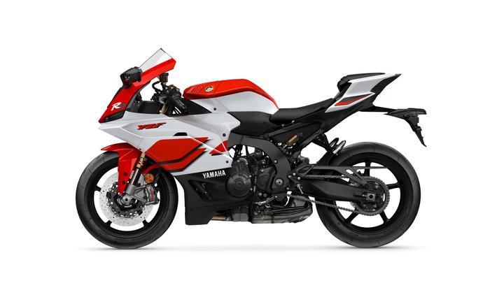 A sleek Yamaha YZF-R1 sport motorcycle in a red, white, and black color scheme, showcasing its aerodynamic design and detailed components side view.
