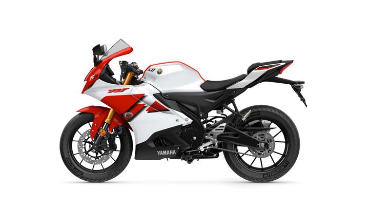 A side view of a Yamaha YZF-R25 motorcycle in white and red color scheme, showcasing its sporty design and features, including the windshield, sleek bodywork, and modern tires.