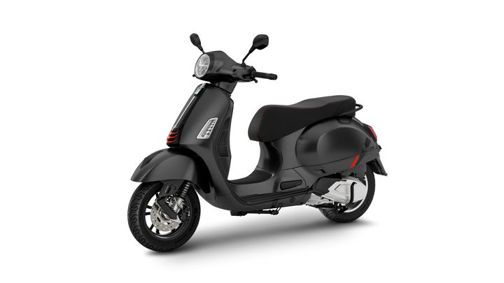 A sleek black scooter with a modern design, featuring a rounded body, a comfortable seat with red stitching, and stylish front and rear lights. The scooter is positioned at an angle, showcasing its wheels and detailed features.