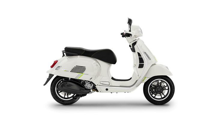 A sleek white scooter with black accents and distinctive green stripes, featuring a retro design, positioned against a plain white background.