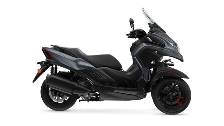 A sleek, modern scooter with a dark gray body, featuring a comfortable seat, tinted windshield, and stylish wheels with red accents, shown from the side against a white background.
