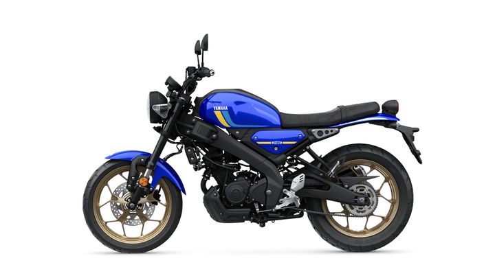 A blue Yamaha motorcycle with a modern design, featuring a black seat and gold alloy wheels, shown from the side against a white background.