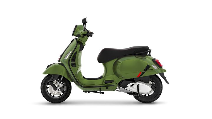 A green scooter with a sleek design, featuring a black seat and chrome accents, positioned against a white background.