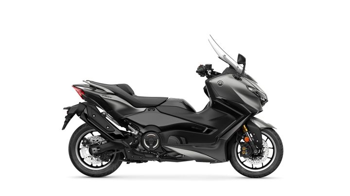 A sleek black scooter with a streamlined design, featuring a tall windshield, comfortable seating, and large wheels, positioned against a plain white background.