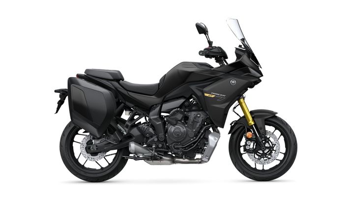 A black motorcycle with a streamlined design, featuring a tall windscreen, side luggage, and an exposed engine, set against a white background.