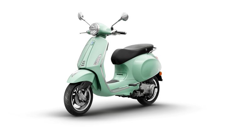 A mint green scooter with a retro design, featuring a black seat, chrome details, and a classic headlight, positioned against a white background.