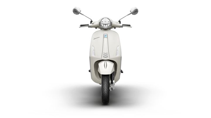 Front view of a cream-colored scooter with a round headlight and two rearview mirrors, set against a white background.