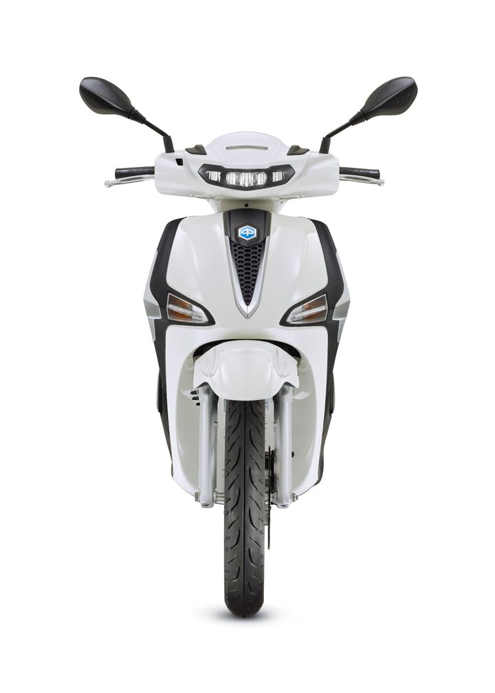 A front view of a white scooter, showcasing its sleek design, headlights, and handlebars. The visible tire is thick, indicating sturdiness, while the body features black accents and a logo at the center.