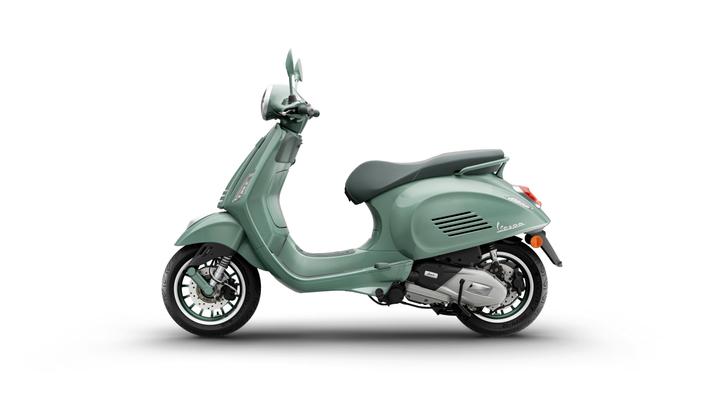 A side view of a mint green Vespa scooter positioned on a white background.