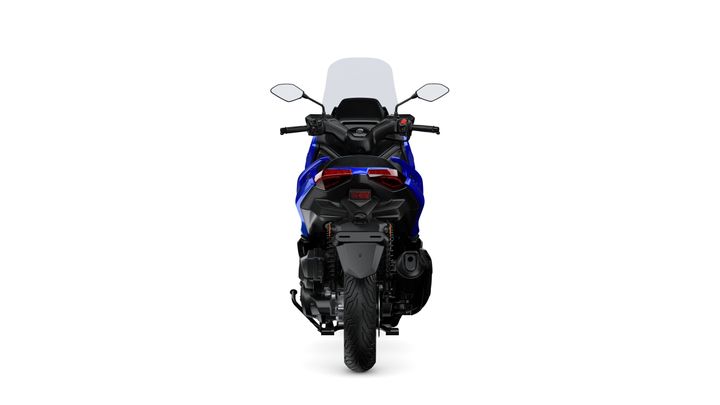 A blue motorcycle viewed from the rear, showcasing its tail lights, exhaust, and rear tire against a white background.