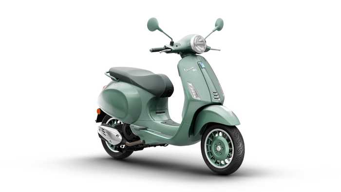 A mint green scooter with a vintage design, featuring a round headlight, chrome accents, and a comfortable seat. The scooter stands on a white background, showcasing its curves and details.