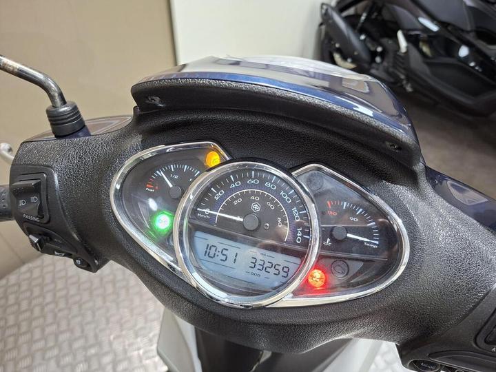 Dashboard view of a scooter displaying speedometer, odometer reading 33,259 miles, fuel gauge with half-full indication, temperature gauge, and warning lights.