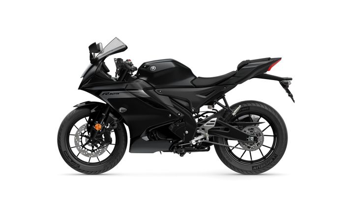 A sleek, black Yamaha R125 motorcycle is displayed from the side, featuring angular bodywork, a sporty design, and distinct wheels.
