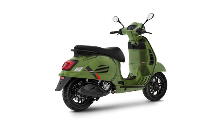 A green scooter angled from the rear, showcasing its sleek design, black seat, and modern features, set against a white background.