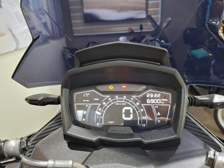 Digital motorcycle dashboard displaying speed, RPM, fuel level, engine temperature, and odometer readings with a modern design.