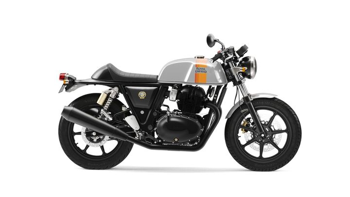 A modern classic motorcycle with a silver and orange tank, black frame, and blacked-out engine and exhaust, set against a white background.