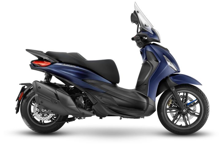 A blue scooter with a sleek design, featuring a windscreen, comfortable seat, and dual-tone bodywork. The side view highlights the scooter's curves, rear suspension, and distinct wheel.