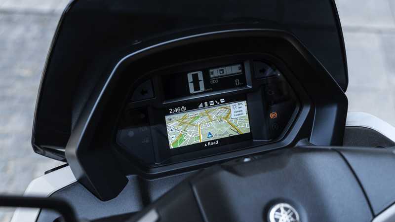 Close-up of a motorcycle's dashboard featuring a digital display with a navigation map, speed indicator, and other metrics. The time reads 2:46 PM and the temperature is 32°C.