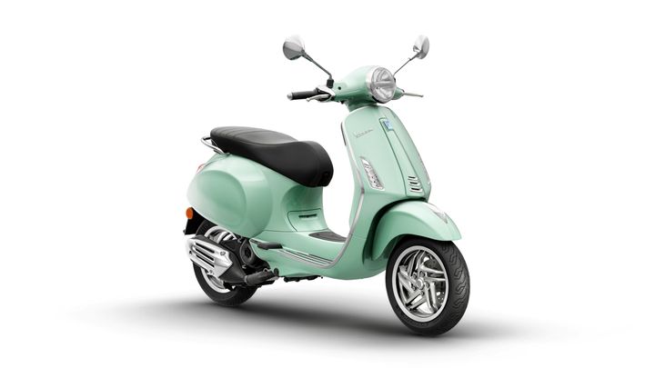 A mint green Vespa scooter angled to the right, showcasing its retro design, sleek body, and chrome details against a white background.
