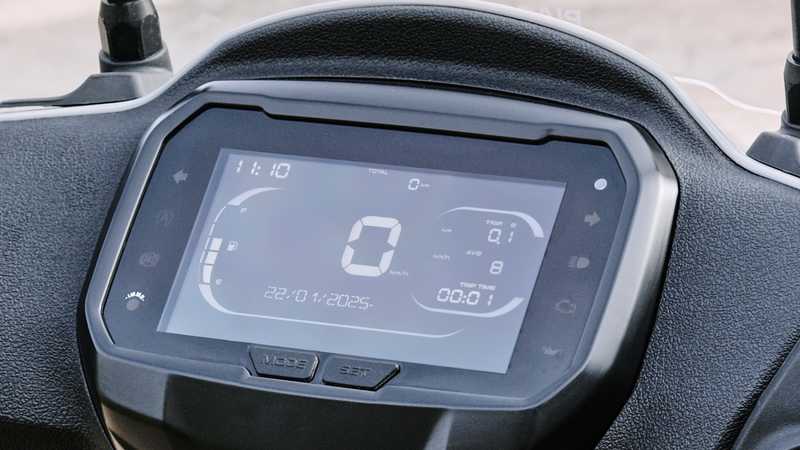 Digital display dashboard of a vehicle showing time, total distance, trip information, and average speed in a sleek interface.