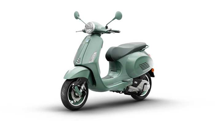 A stylish mint green scooter with a retro design, featuring a round headlight, chrome details, and a comfortable seat, set against a white background.