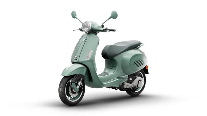 A stylish mint green scooter with a retro design, featuring a round headlight, chrome details, and a comfortable seat, set against a white background.