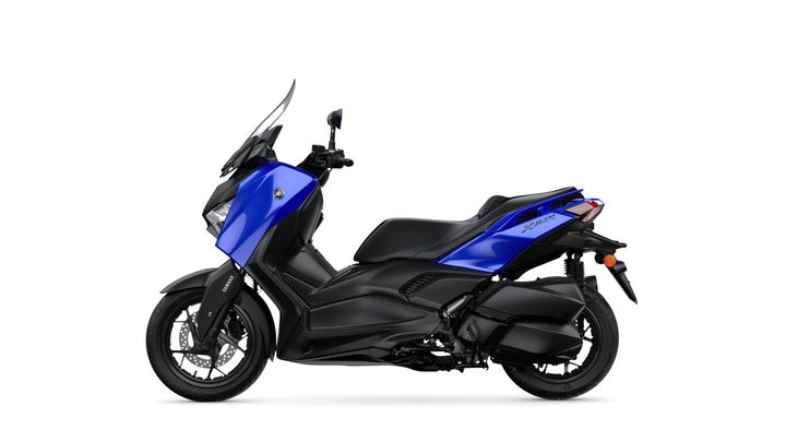 A blue Yamaha XMAX scooter positioned on a white background, showcasing its sleek design, with a prominent windscreen and black accents on the body and wheels.