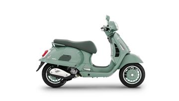 A mint green vintage-style scooter is shown in profile, displaying its sleek design, round headlight, and comfortable seat. The scooter features chrome accents and distinctively patterned wheels.