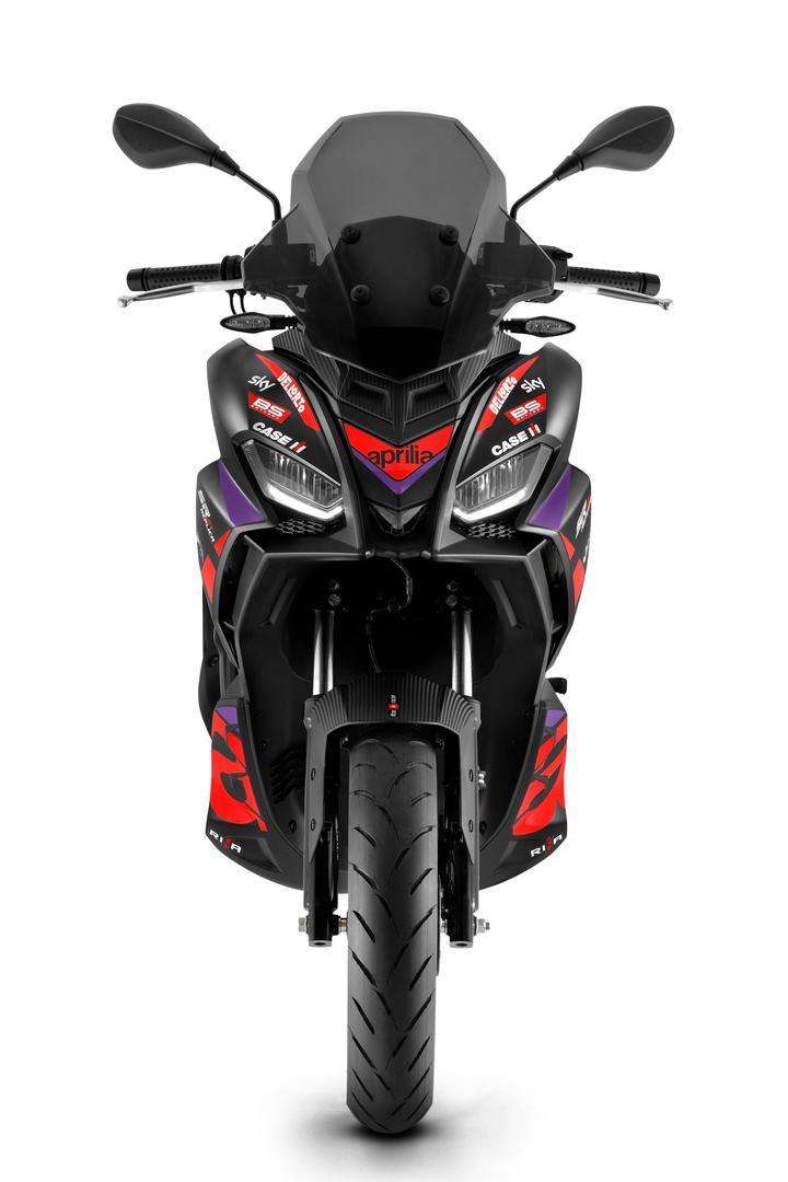 A front view of a modern sports motorcycle with black and red livery, prominent branding, dual headlights, and a windscreen.