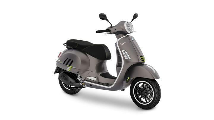 A modern gray scooter with a sleek design, featuring green accents and a comfortable black seat, viewed from an angled side perspective.