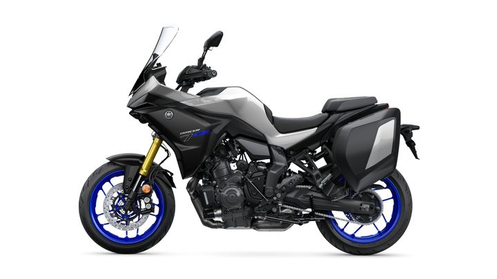 A sleek, modern motorcycle in gray and black with bold blue accents, featuring a streamlined design, side luggage, and a prominent windscreen, positioned against a white background.