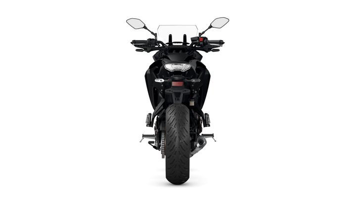 Front view of a sleek, black motorcycle showcasing its handlebars, mirrors, and distinctive tire tread.