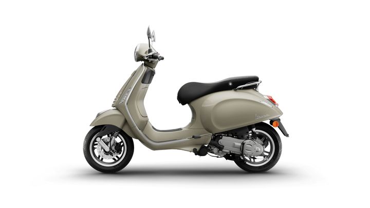 A beige scooter in profile view, featuring a rounded body, black seat, and chrome accents, set against a white background.