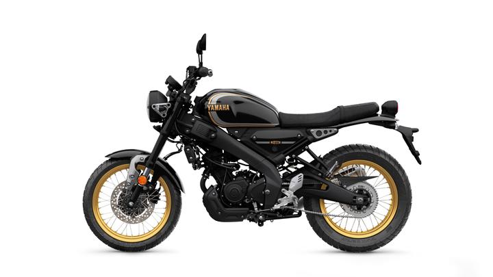 A Yamaha motorcycle with a sleek black design and gold accents, featuring a minimalist frame, large tires, and a comfortable seat, viewed from the side.