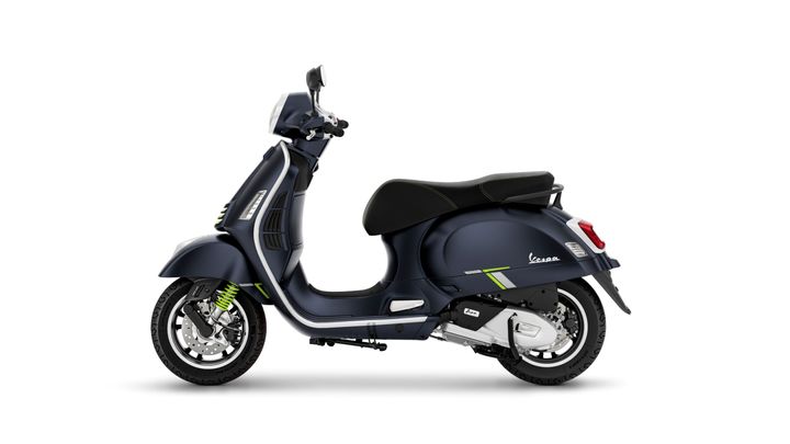 A sleek navy blue Vespa scooter with a stylish design and green accents, viewed from the side on a white background.