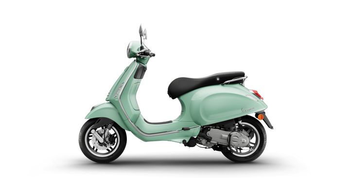A mint green Vespa scooter is displayed from the side, showcasing its sleek design and chrome accents.