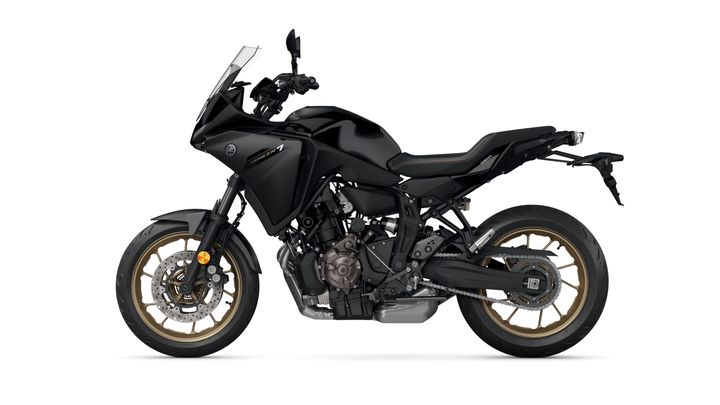 A side view of a sleek black motorcycle with gold rims and a modern design, featuring a prominent windscreen and sporty seating.