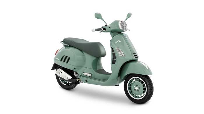 Vespa GTS 80th 310 A mint green Vespa scooter, featuring a comfortable seat, chrome accents, and stylish wheels, positioned at an angle to showcase its design.