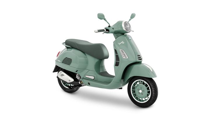 Vespa GTS 80th 310 A mint green Vespa scooter, featuring a comfortable seat, chrome accents, and stylish wheels, positioned at an angle to showcase its design.