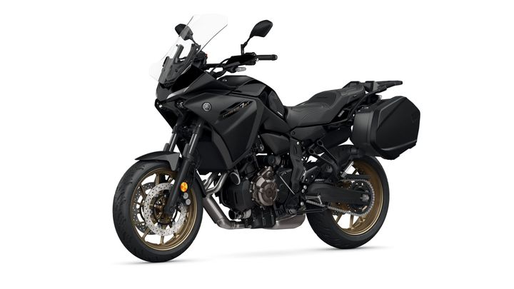 A black Yamaha motorcycle with gold rims and side panniers, positioned at an angle to showcase its sleek design and features.