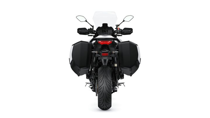 A rear view of a motorcycle with black panniers, a transparent windscreen, and a prominent rear tire, set against a plain white background.