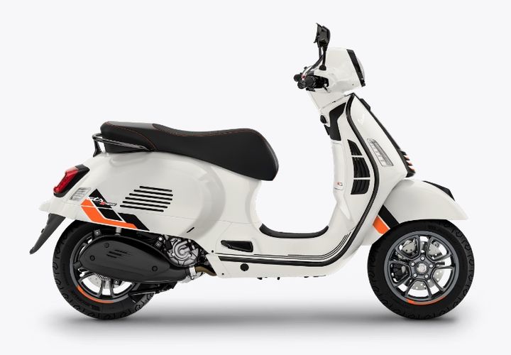 White motor scooter with black and orange trim, displayed in a studio setting against a plain background.