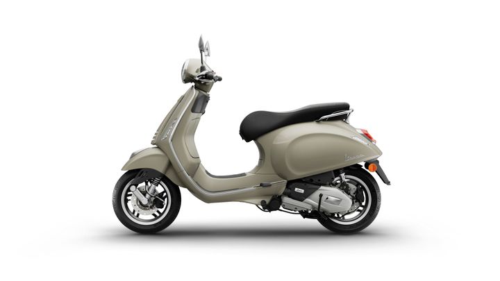 A beige scooter with a sleek design, displaying a side profile view, featuring a black seat, chrome accents, and a front mirror.