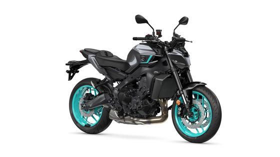 Yamaha 2024 MT-09 A modern motorcycle with a sleek black body and striking turquoise accents on the wheels and frame, positioned at a slight angle to showcase its design and features.